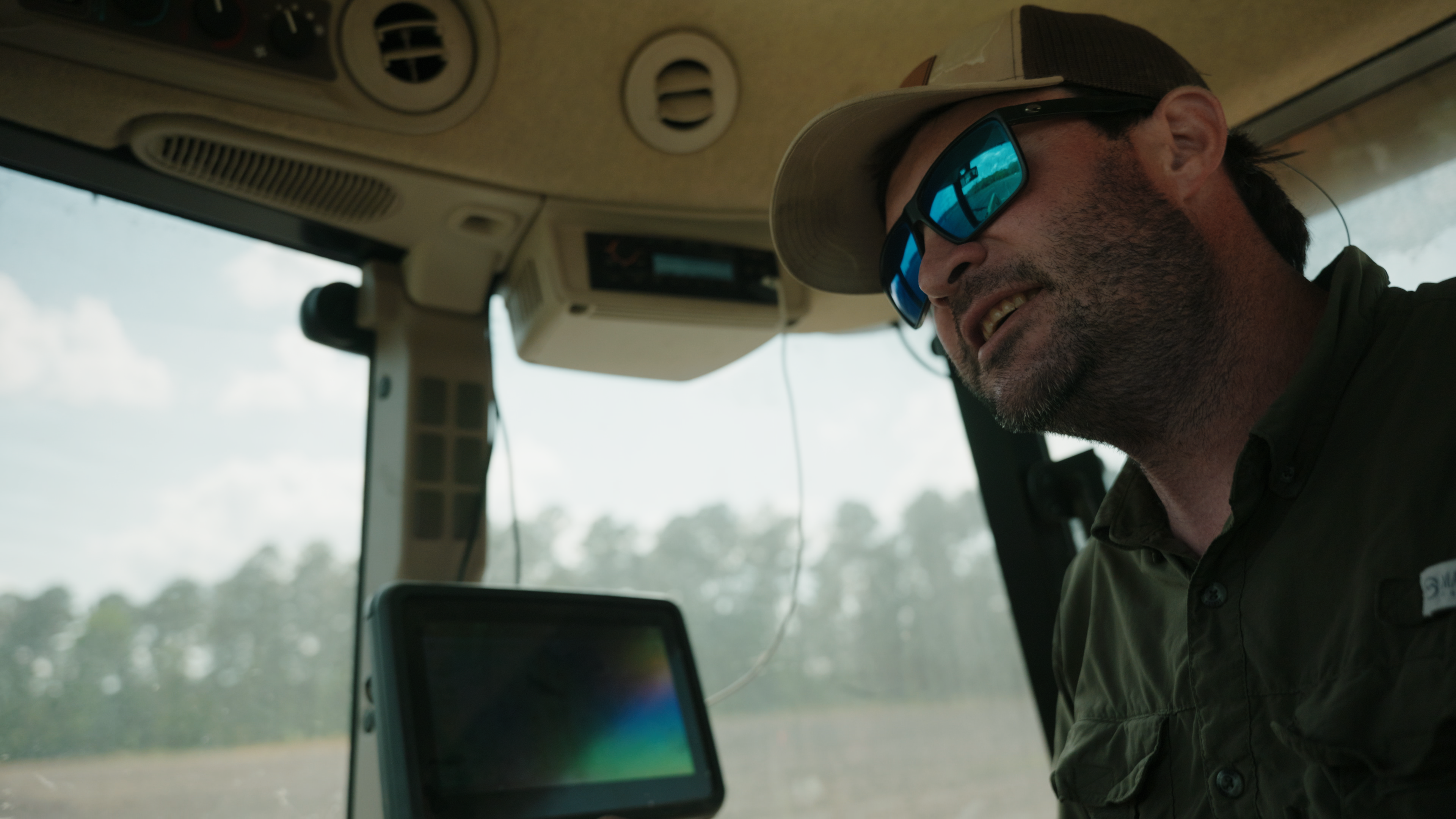 Zane Clardy sitting in his tractor cab in South Carolina, using AutoSteer technology to plant crops on his family farm.